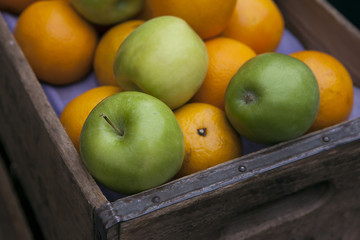 apples and oranges in wooden box