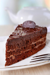 Piece of chocolate cake on plate on light background