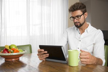 Portrait of a white male using his tablet at home