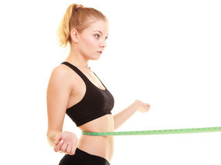 Fototapeta na wymiar diet. slim blonde girl with measure tape measuring waist