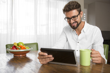 Hispanic male with a beard using the internet at home