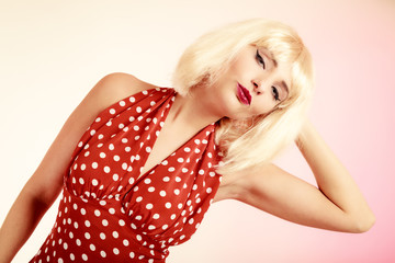 Pinup girl in blond wig and retro dress. Vintage