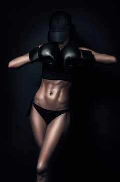 Fit woman with gloves in the dark