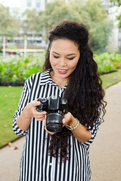 young woman looking through photos on her camera