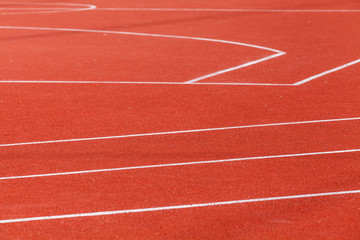 Red sports ground with white marking lines