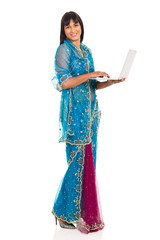 young indian woman in saree using laptop