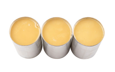 Condensed milk in tin can over white background 