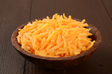 Bowl of grated cheddar cheese