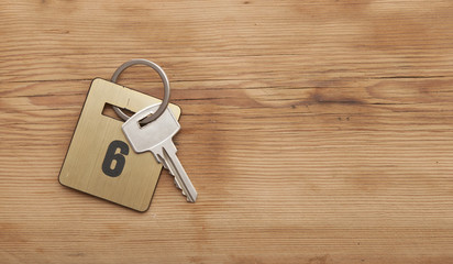 Hotel suite key with room number 6 on wood table