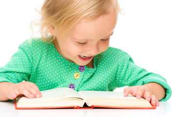 Little girl is reading her book