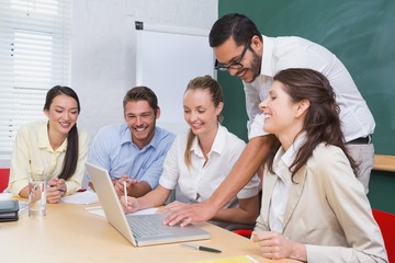 Casual business team having a meeting using laptop