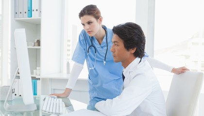 Obraz premium Doctor and surgeon looking at a computer