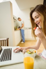 Obraz na płótnie Canvas Woman eating fruit salad at breakfast
