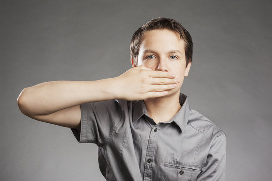 Porträt Teenager Junge: Hält sich Mund zu