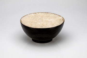 Black bowl with rice, isolated on white background