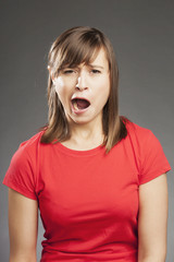 Emotionen: Müde, gähnend. Junge Frau in rotem Shirt