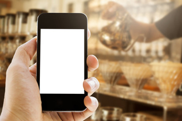 hand holding phone on coffee cafe  background