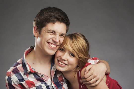 Teenager Paar umarmt sich, freundlicher Blick in die Kamera