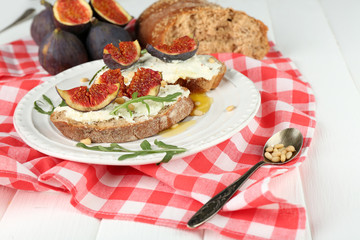 Tasty sandwiches with sweet figs and cottage cheese on plate