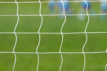 Soccer behind goal net