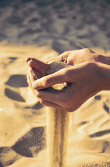 tinted image sand pours out of the female hands