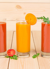 Glasses full of tomato and carrot fresh juice.