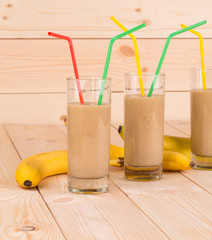 Close up of banana smoothie and fruits on wood.