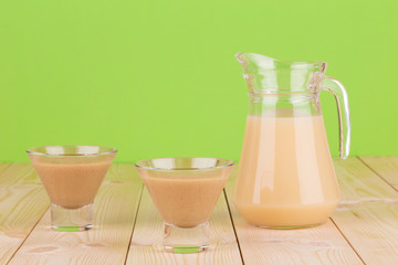 Jar and glasses full of banana juice.