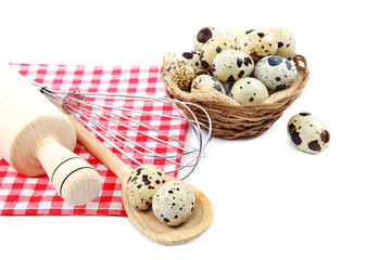 Quail eggs, flour and cooking utensils on canvas.