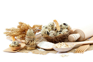 Quail eggs, flour and cooking utensils on canvas.