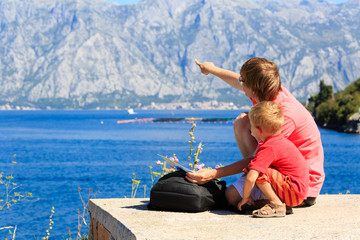 father and son looking at map in mountains