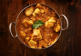 overhead photo of a batli dish with indian butter chicken curry