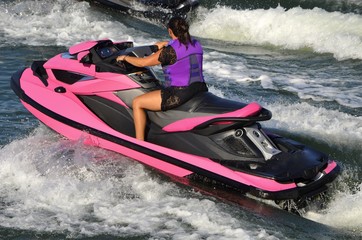 Fototapeta na wymiar Lady on a Bright Pink Jet Ski