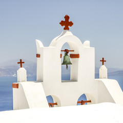Fototapeta premium view of bell tower in oia santorini and part of caldera