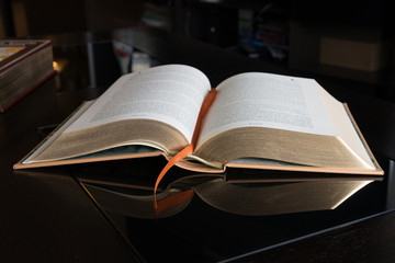 A book on a black mirror surface