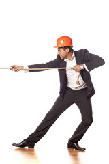 African businessman with a helmet pulling a rope