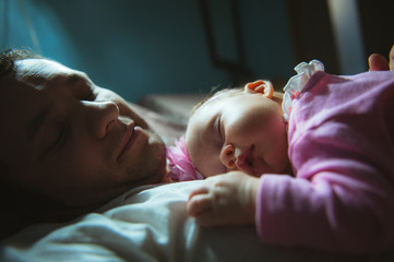 Image of young dad with cute little daughter in his arms