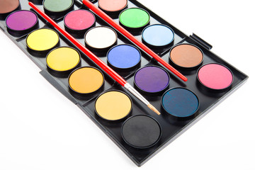 colorful watercolors paints in palette with brushes isolated on