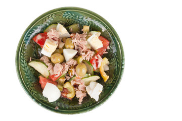 Salad of tuna with vegetables and cheese in a green bowl isolate