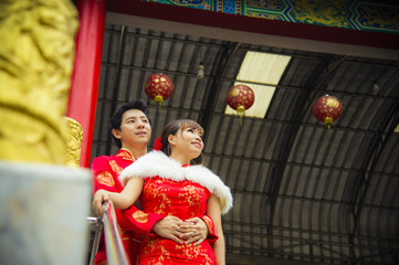 Obraz premium Lovely couple with qipao suit hug in Chinese temple