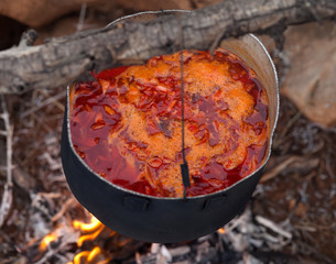 Cooking borscht (Ukrainian traditional soup) on campfire