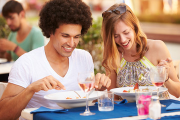 Young Couple Enjoying Meal In Outdoor Restaurant