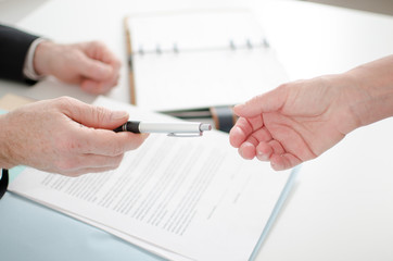 Businessman giving a pen for signature