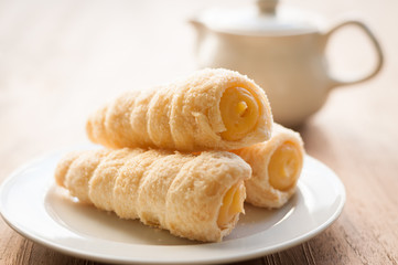 Cream-filled pastry roll on the wood board