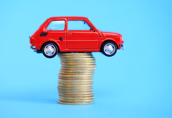 Red miniature car on coin stack