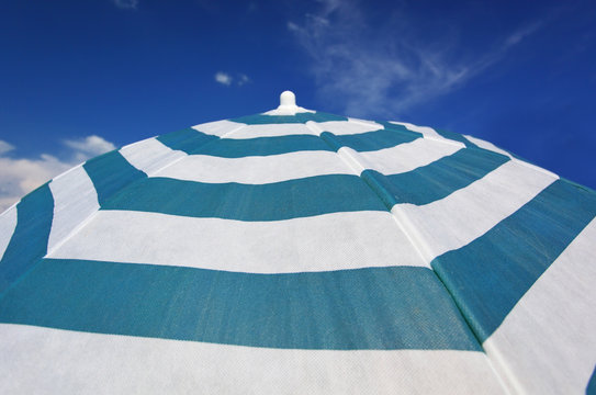 Stripped beach parasol at blue sky