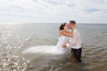 couple de mariés dans l'eau de la mer