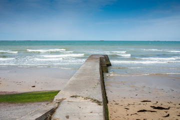 Arromanches les Bains beach with the remains of the Mulberry har