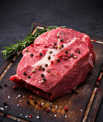 Raw beef steak on wooden table, close-up