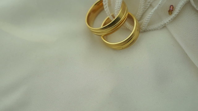 Wedding rings on ring pillow turning